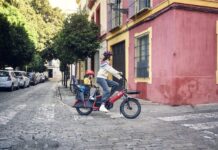 Riese & Müller Multitinker2 (2027): akkora, mint egy túrabringa, és elviszi a családot Riese & Müller Multitinker2 vario lávapiros, gyerekkel a hátsó ülésen a városban